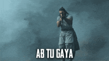 a man is holding a gun and the words ab tu gaya are above him