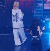 a person wearing a hoodie that says ' i love you ' on it stands next to another person on a stage