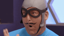 a man wearing a helmet and goggles has a mustache painted on his face .