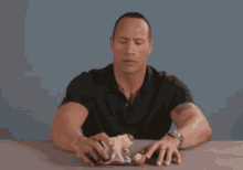 a man is sitting at a table playing with a toy .