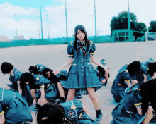 a girl in a blue dress stands in front of a crowd