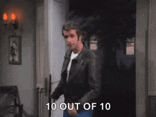 a man in a leather jacket is standing in a doorway and talking .