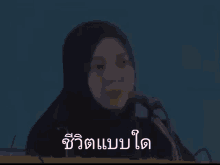 a woman wearing a hijab is talking into a microphone .
