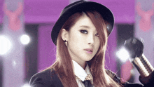 a woman is wearing a hat and holding a microphone