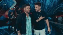 two men are standing next to each other on a stage with rtve written on the bottom