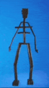 a wooden skeleton statue is standing in front of a blue sky .
