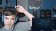 a young man wearing headphones looks at a screen that says victory