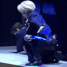 a man in a blue shirt is kneeling down