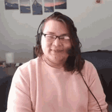 a woman wearing glasses and a headset is sitting at a desk .