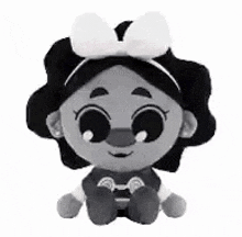 a black and white photo of a stuffed animal with a bow .