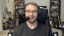a man wearing headphones and glasses is sitting in a chair