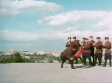 a group of men in military uniforms are standing on a concrete surface