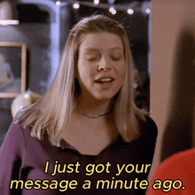 a woman in a purple shirt says i just got your message a minute ago