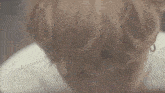 a close up of a person 's face with their eyes closed and a white shirt on .