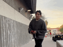 a man walking down a sidewalk in front of a building that has a sign on it that says phoenix