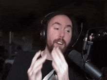 a man with a beard wearing headphones speaking into a microphone