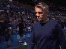 a man in a blue shirt is standing in front of a crowd