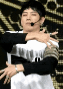 a man wearing a microphone and a ring on his finger is dancing