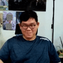 a man wearing glasses and a blue shirt with the word staunch on his shoulder