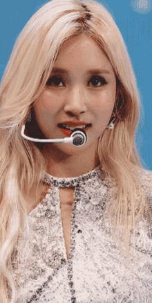 a close up of a woman wearing a microphone around her neck