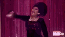 a woman in a black dress is dancing on a stage .
