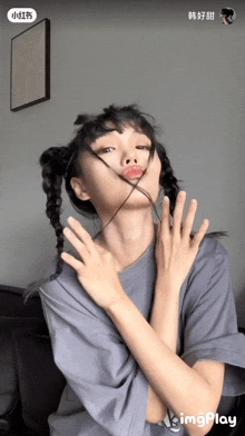 a woman is making a funny face with her hands in front of her face and the word imgplay is on the bottom