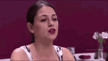 a woman is sitting at a table in a restaurant talking to a man .