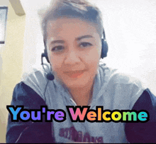 a woman wearing headphones and a shirt that says ' you 're welcome '