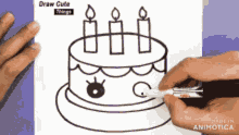 a person is drawing a birthday cake with three candles on it