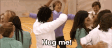 a group of people are hugging each other in a gym with the words hug me .