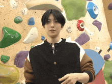 a man standing in front of a climbing wall with the number 36 on the wall