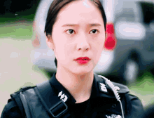 a close up of a woman wearing a police uniform with the letter w on her collar