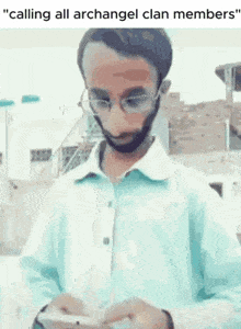 a man with glasses and a beard is looking at a cell phone with the caption " calling all archangel clan members "