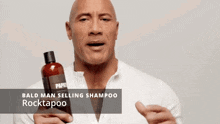 bald man holding a bottle of bald man selling shampoo rocktapoo