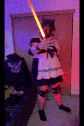 a person in a costume is holding a lightsaber