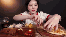 a woman is eating a slice of pizza with her hands
