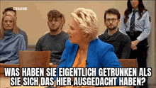 a woman is speaking into a microphone in front of a group of people .