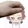 a hand is holding a stuffed animal on top of a person 's head .