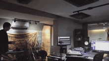 a man stands in a recording studio with the letter d on the bottom right