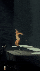 a woman in shorts is dancing on a stage in front of a crowd