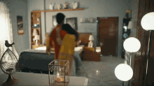 a man and woman are dancing in a bedroom with a candle in a cage