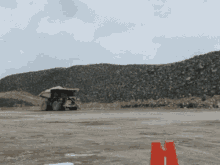 a large truck is driving down a dirt road
