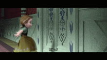 a little girl in a dress is standing in front of a wall with the words elsa on it .