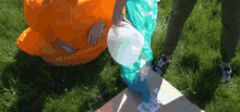 a person in an orange costume holds a white balloon in their hand