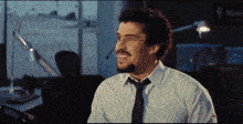 a man with glasses and a tie is smiling
