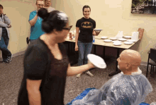 a woman wearing a batman shirt is throwing a plate at a man
