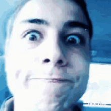 a close up of a person 's face with a surprised look on their face