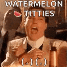 a man in a suit and tie is sitting at a table with a watermelon in his hand .