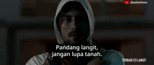 a man in a white hoodie with the words " pandang langit jangan lupa tanah " on the bottom