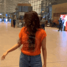 a woman wearing an orange shirt that says teddy masala on it